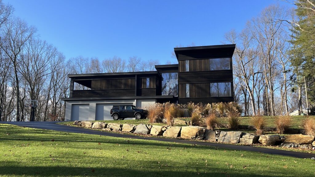 Modern exterior painting project in Westport CT with dark siding and strong architectural lines