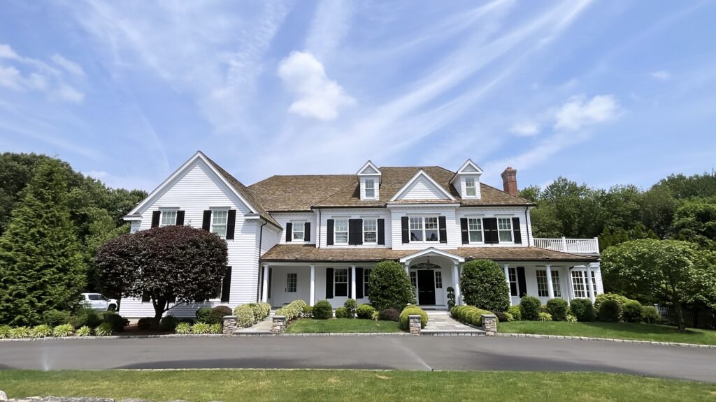 Exterior painting project in New Canaan CT with bright white siding and crisp black shutters
