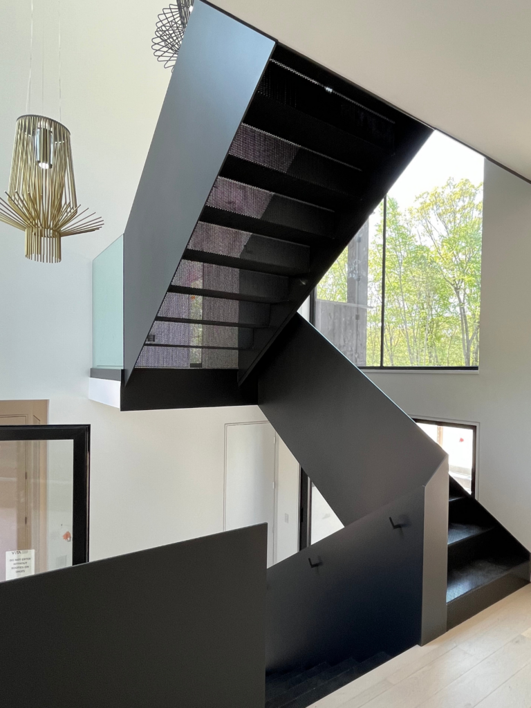 Interior painting project in Westport CT with a bold black staircase and bright white walls